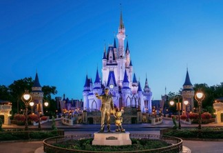 Castelo da Cinderela e Estátua de Walt Disney ao anoitecer no Magic Kingdom da Disney Orlando
