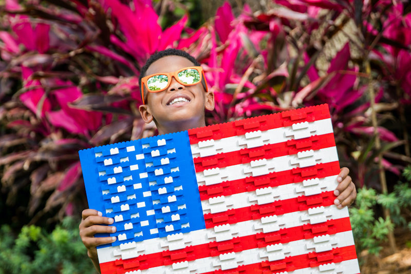 Criança com bandeira dos Estados Unidos no festival Awe-Summer Celebration no Legoland Florida