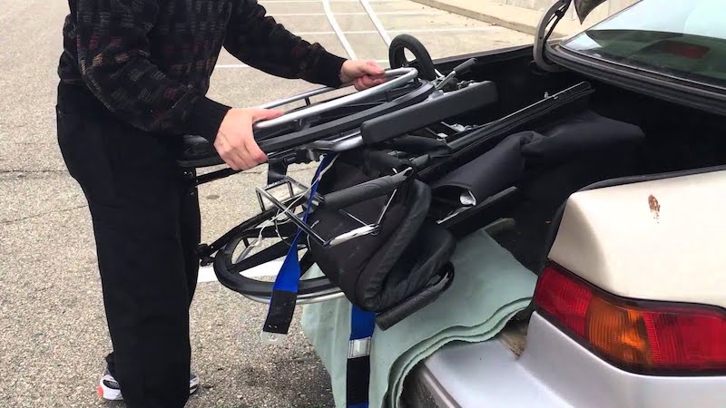 Colocando cadeira de rodas no porta-malas do carro