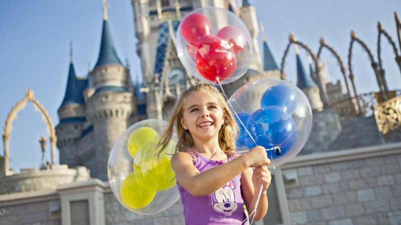Criança feliz com balões na Disney Orlando